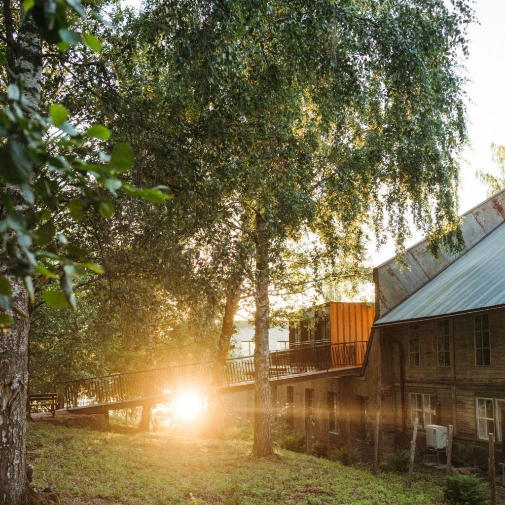 Auringonlasku Mathildedalin Ruukilla. Kuvassa oikealla näkyy auringonlaskun valaisema puinen puusepänverstas.