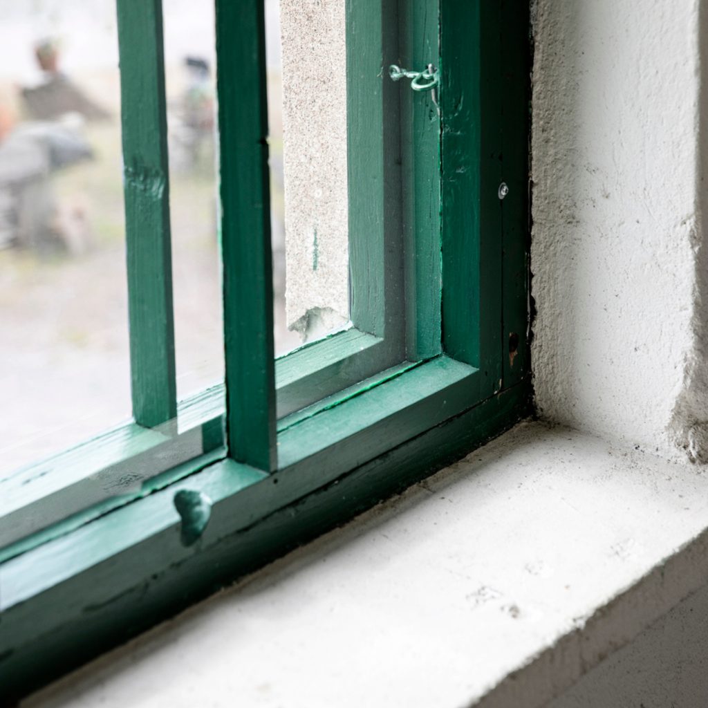 Vihreät ikkunanpokat ja kivinen ikkunalauta Konttori palaveritilassa.